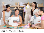 Group of happy attendees of dressmaking courses engaged in different activities. Стоковое фото, фотограф Яков Филимонов / Фотобанк Лори
