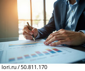 The 2025 New Year business goals concept. Businessman analyzes graph of trend market growth in 2025 and plans business growth and profit increases. calculates financial data. Стоковое AI-изображение, AI-художник Sergey Grishin / Фотобанк Лори