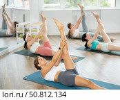 Girls at group Hatha yoga class does preliminary preparatory stretching. Стоковое фото, фотограф Яков Филимонов / Фотобанк Лори