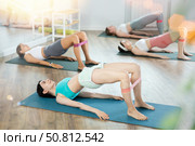 Girls perform exercises lying on side with legs straightened and narrow elastic band on shins. Стоковое фото, фотограф Яков Филимонов / Фотобанк Лори