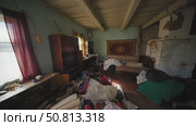 Messy living room in abandoned slavic village house with clothes scattered on floor. Стоковое видео, видеограф Mikhail Davidovich / Фотобанк Лори