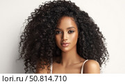 Beautiful laughing brunette model african woman with long curly hair . Smiling gir afro hairstyle wavy curls . Fashion , beauty and makeup portrait . Dark skin , Beauty cosmetology portrait. Стоковое фото, фотограф Sofia Zhuravetc / Фотобанк Лори