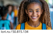 Back to School: Close-up portrait of a smiling girl wearing a yellow shirt and backpack, ready for education. Стоковое AI-изображение, AI-художник Данила Большаков / Фотобанк Лори