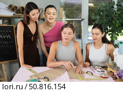 Young sewing instructor explaining pattern placement to students. Стоковое фото, фотограф Яков Филимонов / Фотобанк Лори