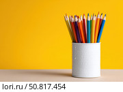 Close-Up of Vibrant Colorful Pencils in a pen holder isolated on yellow background. Banner, copy space. Colourful sharpened colored pencils for art projects, drawing, and creativity. Back to school. Стоковое AI-изображение, AI-художник Марина Демидюк / Фотобанк Лори
