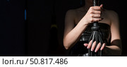 BDSM concept. A woman in a leather corset holds a black lash with a long fringe. Role-playing games for adults. Close-up of sex toys for domination. The whip in female hands. Стоковое фото, фотограф Михаил Решетников / Фотобанк Лори