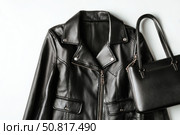 Black leather jacket with zippers and pockets and black leather stylish bag. Modern outerwear. Close-up. Fashion background. Autumn urban street clothes. Fashionable concept. Women's casual day outfit. Стоковое AI-изображение, AI-художник Марина Демидюк / Фотобанк Лори
