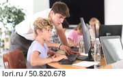 Guy teacher teaches boy student to work with computer. Стоковое видео, видеограф Яков Филимонов / Фотобанк Лори