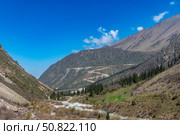 Ala-Archa Park, Mountainous terrain featuring a winding path, flowing river, pine trees, steep slopes, inviting setting for trekking, hiking, mountaineering, adventure, and nature exploration. Стоковое фото, фотограф Андрей Ка / Фотобанк Лори