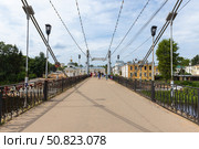People walk the Pedestrian bridge over Tvertsa river on a sunny day. Редакционное фото, фотограф EugeneSergeev / Фотобанк Лори