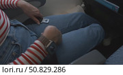 Close-up of female hands fastening and unfastening seat belt on airplane seat during flight, woman demonstrates safety procedures for passengers on board commercial aircraft, travel safety concept. Стоковое видео, видеограф Сергей Тимофеев / Фотобанк Лори