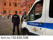 Police officers are on duty near a patrol car.  Russia. Moscow. 21.07.25. Редакционное фото, фотограф Ярославский Максим / Фотобанк Лори
