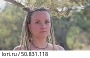 Girl with dreadlocks eats a cracker on the street. Стоковое видео, видеограф German Zvyagin / Фотобанк Лори