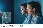 Dedicated and Focused Programmers Conducting Thorough Analysis of Code on Two Dual Monitors. Стоковое AI-видео, аниматор Лариса Пономарева / Фотобанк Лори