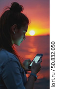 Beautiful and inspiring young woman over epic night sea background. Millennial female with screen lit face, cool and trendy teenager looking woman. Smartphone application market, Стоковое AI-видео, аниматор Sergey Grishin / Фотобанк Лори