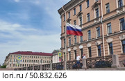 Visitors admire the beautiful architecture of St. Petersburg. The Russian flag flutters proudly against the backdrop of buildings. St. Petersburg, Russia, July 14, 2025. Редакционное видео, видеограф Наталия Попова / Фотобанк Лори