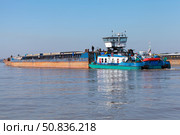 Rear view of a blue and white tugboat pushing a barge on Danube river. Стоковое фото, фотограф EugeneSergeev / Фотобанк Лори
