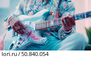 Musical Elegance: Person playing a guitar adorned with gemstones and wearing a floral shirt, a harmonic blend of music and personal adornment. Стоковое AI-изображение, AI-художник Данила Большаков / Фотобанк Лори
