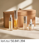 Elegant display of skincare oils and serums in minimalistic packaging on soft fabric background. Стоковое AI-изображение, AI-художник Сергей Толмачёв / Фотобанк Лори