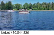 Boating and relaxation on a sunny day on the shore of the Vyborg Bay against the backdrop of green trees - Vyborg, Russia, July 15, 2025. Редакционное видео, видеограф Наталия Попова / Фотобанк Лори