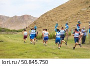 ELANTSY VILLAGE, IRKUTSK REGION, RUSSIA - July 5, 2025: Erdyn Games - festival of nomadic peoples of Eurasia. Athletes run traditional cross around sacred mountain of Erd on summer sunny day. Редакционное фото, фотограф Виктория Катьянова / Фотобанк Лори