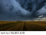 Dark storm clouds in an agricultural field in autumn. An impending storm, hurricane or thunderstorm. Стоковое фото, фотограф Емельянов Евгений Викторович / Фотобанк Лори