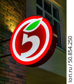 Russia, Kaluga - DECEMBER 27, 2021: Luminous logo of the Russian retailer Pyaterochka on a wall in night. Редакционное фото, фотограф Емельянов Евгений Викторович / Фотобанк Лори