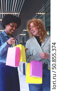 Happy multiracial friends holding colorful shopping bags in modern mall. Стоковое видео, видеограф Raquel Corcoles Mendez / Фотобанк Лори