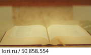 Open Bible on marble altar in warm light inside a church. Стоковое видео, видеограф Igor Tichonow / Фотобанк Лори
