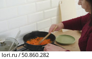 Senior active woman cooking lunch at home in modern kitchen. Healthy eating, food and culinary concept. Hands of old lady with knife chopping vegetables, grating carrots. Elderly female cook a soup. Стоковое видео, видеограф Марина Демидюк / Фотобанк Лори