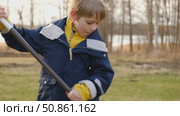 Boy Raking Up Autumn Leaves at the Home Backyard. Fall season. Seasonal garden yard work outside. Busy blonde child helps to mom gardening autumnal lawn. Cute kid learn planting. Young Raker. Chores. Стоковое видео, видеограф Марина Демидюк / Фотобанк Лори