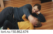 Caucasian bearded strong father with one child boy doing push ups on floor in living room. Family fitness gym at home. Sporty dad and son piggy back having fun exercise. Funny sport with kid. 4k video. Стоковое видео, видеограф Марина Демидюк / Фотобанк Лори