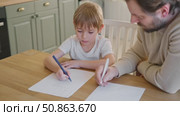 Dad teaches his son writing and counting. Kids primary education. Children learn, study in home school. Daddy male helping teaching little child boy support studying, learning homework. Knowledge day. Стоковое видео, видеограф Марина Демидюк / Фотобанк Лори