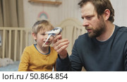 Father and son enjoying at home. Young boy and his daddy playing with funny pet budgerigar parrot. Happy family. Tamed budgie parakeet. People take care of and play with bird. Cute domestic animals. Стоковое видео, видеограф Марина Демидюк / Фотобанк Лори