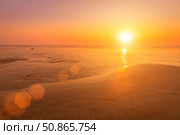 A colorful sunset or sunrise on the seaside with a sandy beach with impurities of volcanic ash. Mandrem, Goa, India. (2018 год). Стоковое фото, фотограф Емельянов Евгений Викторович / Фотобанк Лори