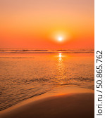 A colorful sunset or sunrise on the seaside with a sandy beach with impurities of volcanic ash. Mandrem, Goa, India. (2018 год). Стоковое фото, фотограф Емельянов Евгений Викторович / Фотобанк Лори