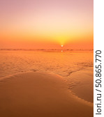 A colorful sunset or sunrise on the seaside with a sandy beach with impurities of volcanic ash. Mandrem, Goa, India. (2018 год). Стоковое фото, фотограф Емельянов Евгений Викторович / Фотобанк Лори