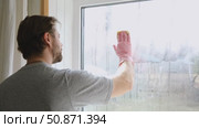 Man is cleaning window in apartment. Adult Male cleaner using a squeegee to wash a window. Bearded guy wiping and washing glasses with with spray bottle, rag and vacoom. Everyday chores. Purification. Стоковое видео, видеограф Марина Демидюк / Фотобанк Лори