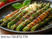 A close-up of crispy fried asparagus topped with grated cheese and fresh herbs. The dish is served on a dark plate, with basil leaves and some tomatoes visible in the background. This appetizing and juicy shot is perfect for food blogs, restaurant menus, healthy recipes and vegetarian cuisine articles. Natural light, bright colors and texture make the image especially attractive for gastronomic themes. Стоковое AI-изображение, AI-художник Анна Кривицкая / Фотобанк Лори