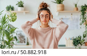 Stressful Day: Woman Closing Her Ears to Escape the Noise & Find Peace in Home, Seeking Serenity from Overwhelm, Indoor Portrait. Стоковое AI-изображение, AI-художник Данила Большаков / Фотобанк Лори