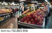 Fresh produce vendors displaying colorful fruits, vegetables at crowded indoor market, highlighting diverse, nutritious food selection with vibrant merchandising arrangement. Стоковое AI-видео, аниматор Данил Руденко / Фотобанк Лори