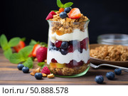 Delicious granola parfait with yogurt and fresh berries layered in glass jar. Стоковое AI-изображение, AI-художник Иван Рябоконь / Фотобанк Лори