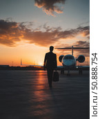 Airport silhouette travel scene with business private aviation executive jet and suitcase by the runway. Luxury evening trip for a focused and ambitious lifestyle. Стоковое AI-изображение, AI-художник Александра Троицкая / Фотобанк Лори