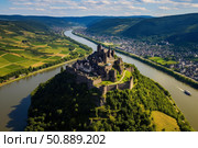 Medieval castle overlooking the moselle river in rhineland palatinate, germany, on a sunny day. Стоковое AI-изображение, AI-художник Иван Рябоконь / Фотобанк Лори