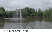Water fountain spraying in calm lake surrounded by trees. Стоковое видео, видеограф Юрий Поздников / Фотобанк Лори