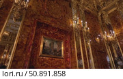 Explore the stunning interior of a grand amber room, featuring intricate gold embellishments and warm candlelight illuminating the walls - Saint Petersburg, Russia, July 13, 2025. Редакционное видео, видеограф Наталия Попова / Фотобанк Лори