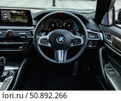 Novosibirsk, Russia -  July 10, 2024: black  BMW 5-series,  Prestige car interior with dashboard, steering wheel, speedometer and tachometer. Black leather interior. Редакционное фото, фотограф Виталий Сова / Фотобанк Лори