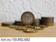 Юбилейная монета со знаком Министерства финансов РФ на фоне других монет. Стоковое фото, фотограф Ирина Григорьева / Фотобанк Лори