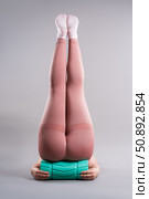 Fat woman in sportswear use myofascial release massage mfr roll on gray background, pelvic floor muscle exercise. Стоковое фото, фотограф Станислав Тарко / Фотобанк Лори