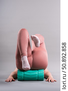 Fat woman in sportswear use myofascial release massage mfr roll on gray background, pelvic floor muscle exercise. Стоковое фото, фотограф Станислав Тарко / Фотобанк Лори